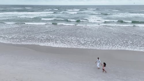 Romantic Couple Holding Hands Walking on the Beach