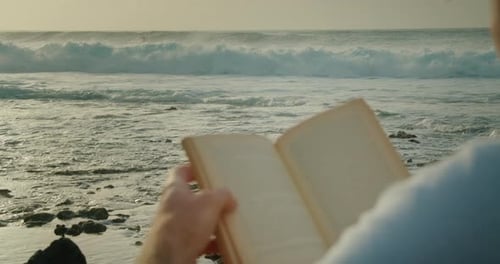 Mann entspannt sich am Strand und liest ein Buch