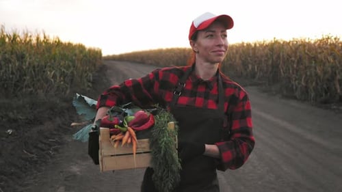 Woman Farmer Carrying Vegetables in Country Cornfield