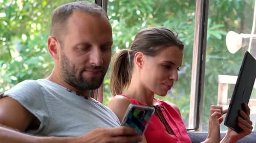 Couple Relaxing Together Using Devices at Home