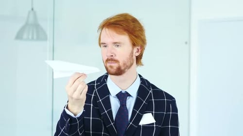 Young Adult with Paper Airplane in Office