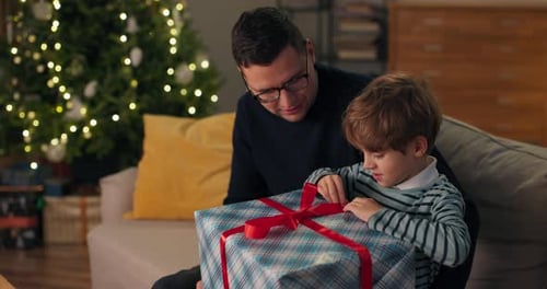 Father and Son Opening Christmas Gift Together