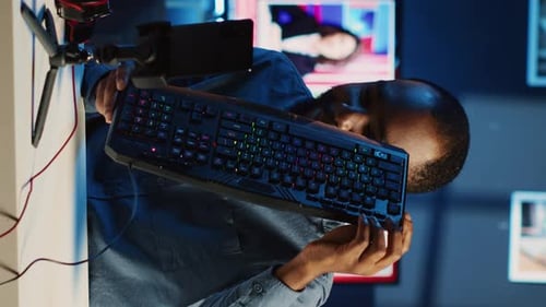 Man Demonstrates Computer Accessories to Smart Phone Camera