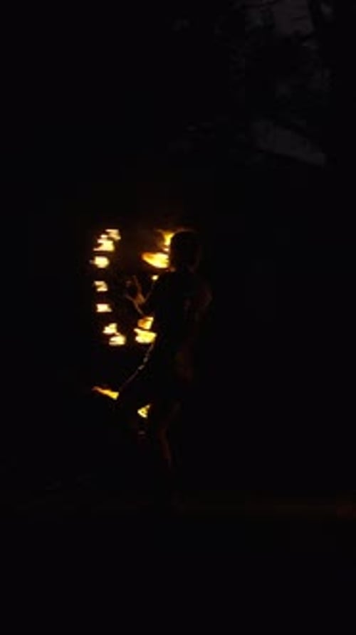 Solo Fire Dancer Performing Mesmerizing Night Routine with Swirling Flames and Dynamic Light Trails
