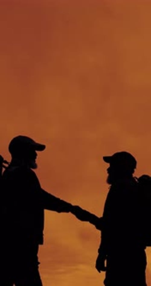 People, silhouette and handshake for hiking goals, sunset sky and friends with space on mountain