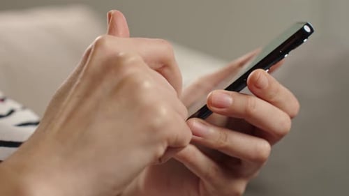Person Browsing Social Media on Smartphone Indoors