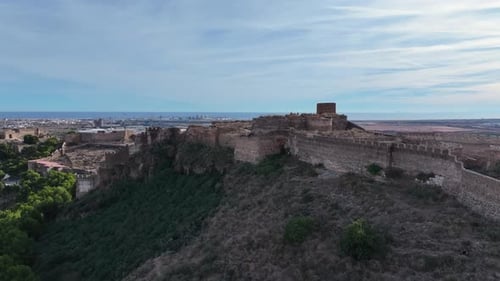 flight with a drone over an imposing medieval fortification located on a hill with a large defensive