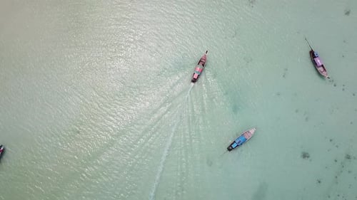 Top Down Drone Aerial View on Thaditional Thai Boat Sailing in Shallow Water on White Sand Beach on
