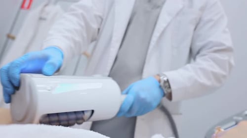 Medical Professional Uses Electronic Device on Patient