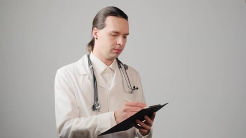 Doctor Writing on Clipboard in Healthcare Setting