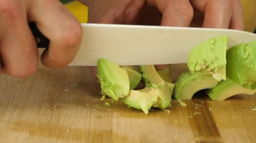Person Chopping Ripe Avocado in the Kitchen