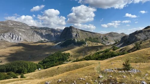 Flight over beautiful mountain peaks covered with grass. Mountain from above on a sunny autumn day.
