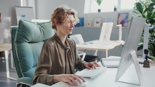 Woman Working at Computer in Modern Office