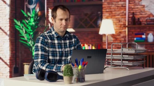 Freelancer em escritório doméstico sentado na mesa e digitando no teclado do laptop
