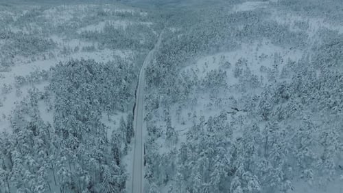Drone shot of EV Opel Ampera driving in beautiful big snowy landscape in Norway.