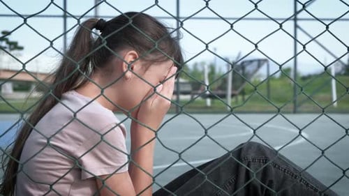 Sad Teen Girl Crying Behind Fence