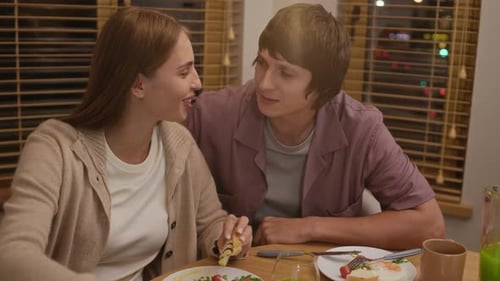 Young Couple Watching Laptop at Dinner Indoors