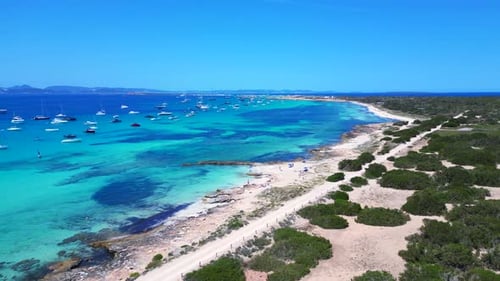 Ibiza coastline, boats in tranquil turquoise water. Perfect aerial view drone