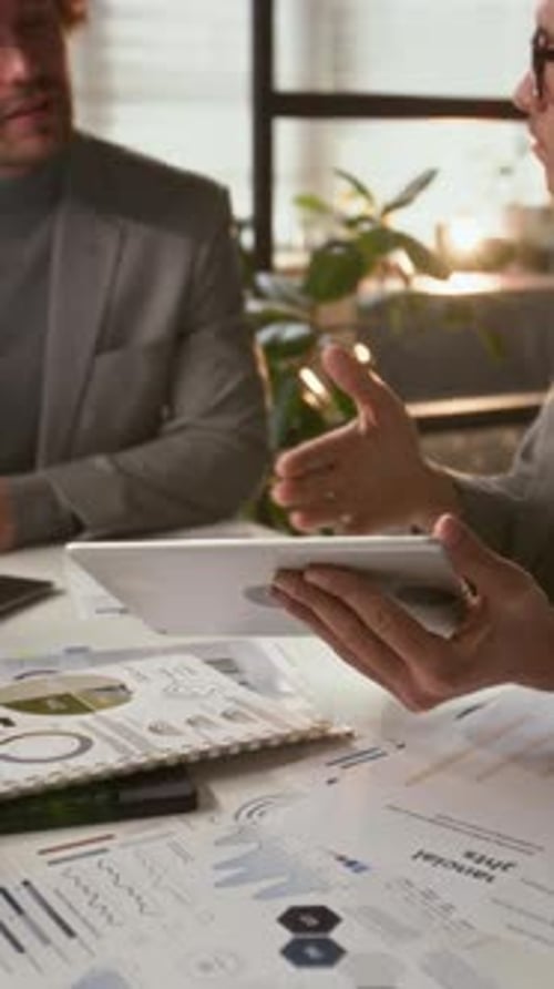 Man Discusses Business Using Tablet in Bright Office