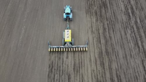 Blue tractor OA working on the field in Ukraine