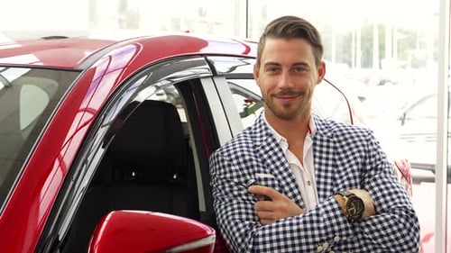 Smiling Man Holds Car Keys at Dealership