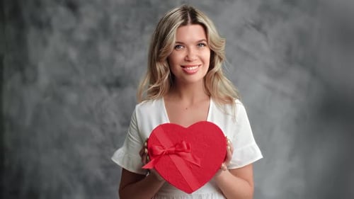 Romantic Woman Holding Red Festive Gift Box Heart Shape Positive Emotion Posing Isolated Gray Studio