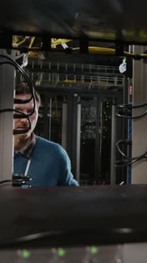 Vertical of Technician Servicing Equipment Inside Data Center Server Cabinet