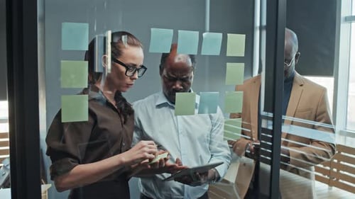 Colleagues Collaborating using Sticky Notes and Tablet