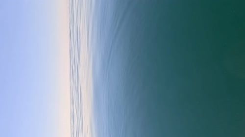 Vertikale Luftaufnahme der Meerwasseroberfläche: Kamera fliegt über klares Meerwasser, Sonnenblendung, abstrakt