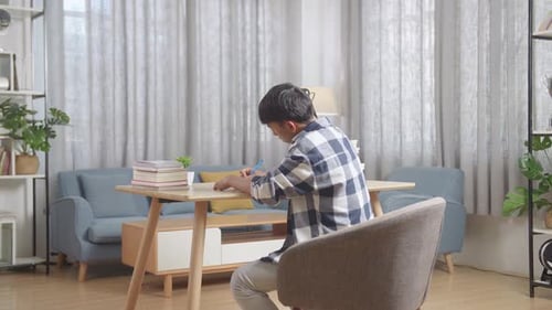 Back View Of Asian Teenager Studying At Home, Asia Teen Writing While Sitting On The Table