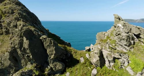 Jagged Rocky Cliffs Over Blue Ocean Aerial Drone Fly Over