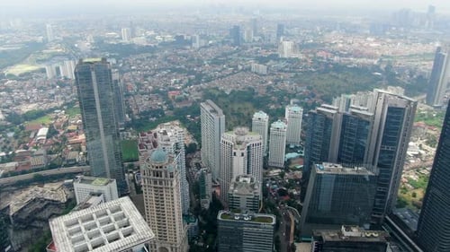 Drone flying over Jakarta skyscrapers at daytime, Indonesia. Aerial forward