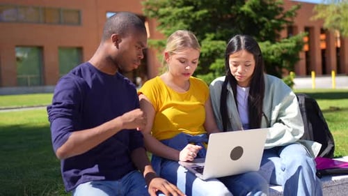 Multiethnic Students Sitting Outside the Campus Using Mobile Phones