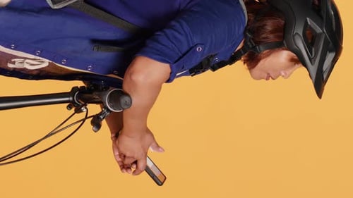 Woman With Bike Helmet Uses Smartphone