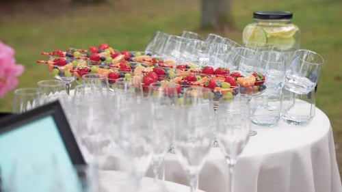 Elegant Fruit Display with Beverages at an Outdoor Event