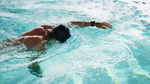 Un nadador atlético que practica en una piscina que domina las técnicas de golpes de estilo libre con precisión y