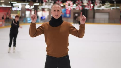 Adult Man Ice Skating Indoors Gesturing