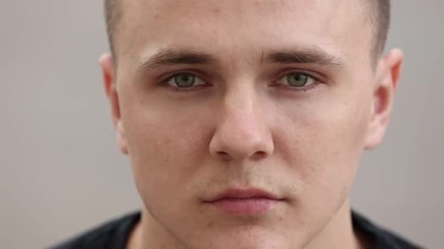 concentrated handsome young man with brown eyes and healthy skin looking to camera