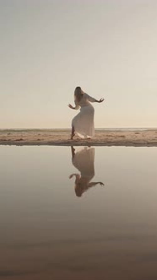 Woman Dancing On Beach At Sunset