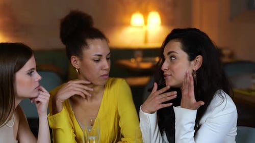 Pretty Woman Sitting in a Restaurant with Her Friends and Telling Them Secret and Showing Wedding