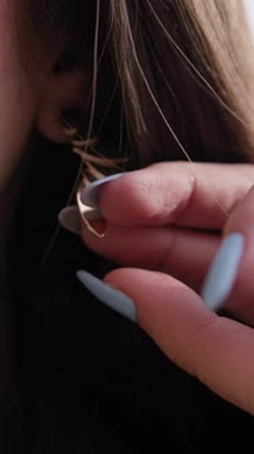 Woman Puts In Gold Leaf Earring