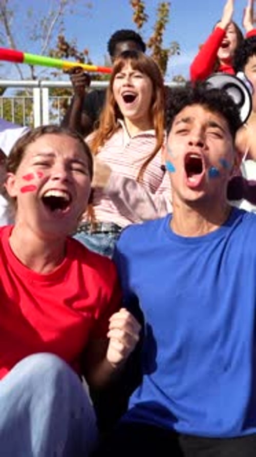 Excited Group of Fans Cheering for Their Favorite Team at a Stadium