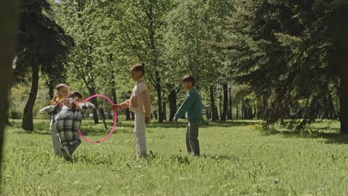 Kids Jumping through Hula Hoop in Park