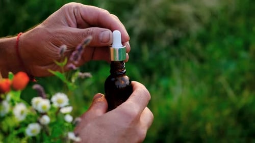 Man with Medicinal Herbal Extracts in His Hands Selective Focus