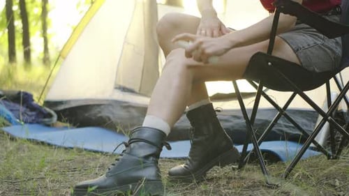 Woman Applies Insect Repellent While Camping