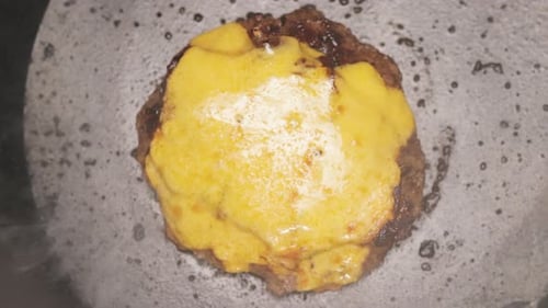 Melting Cheese on Juicy Hamburger Patty in Pan