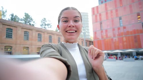 Smiling Woman Waving Hello in City Square