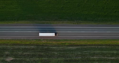 A Truck with a Semitrailer is Driving Along a Straight Highway Aerial View