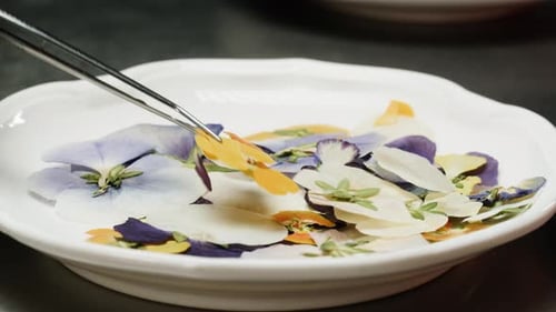 Colorful Pansies Arranged with Tweezers on White Plate