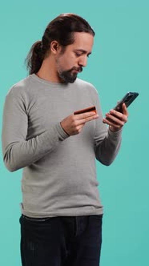 Man Using Credit Card With Mobile Device